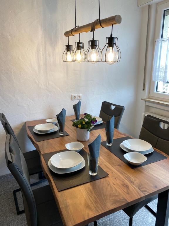 a dining room table with chairs and a wooden table with lights at Ferienhaus Schmidt am Rhein in Neuwied