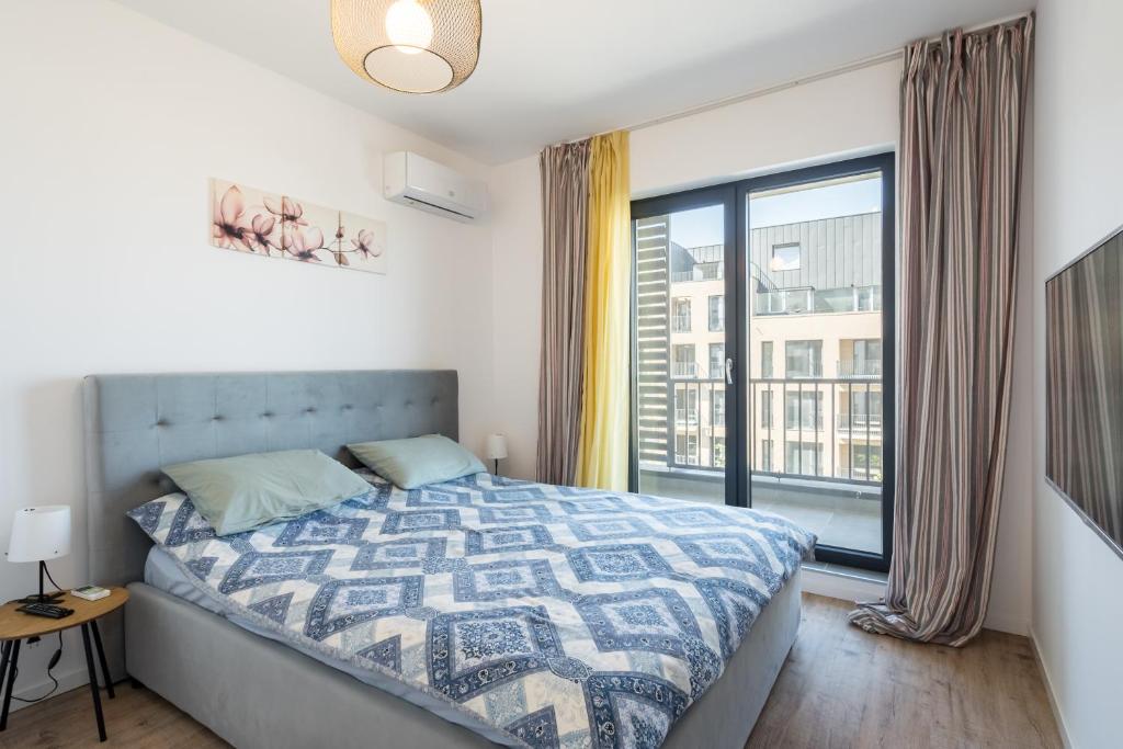 Un dormitorio con una cama y una ventana grande. en H Pipera Lakeview, en Voluntari