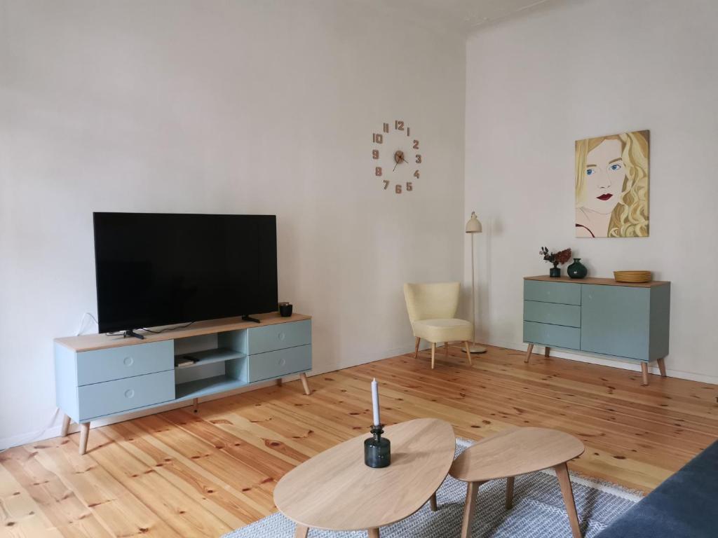 a living room with a flat screen tv on a dresser at Ferienwohnung Potsdam in Potsdam