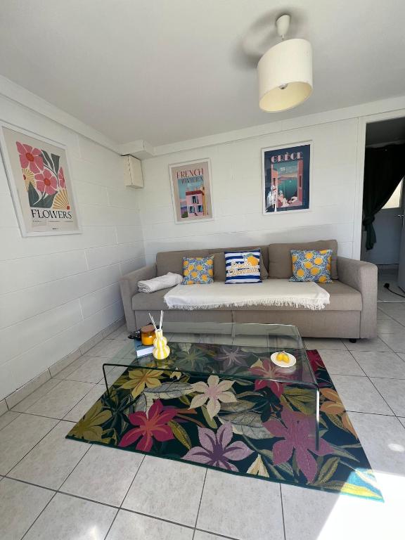 un salon avec un canapé et une table en verre dans l'établissement Le cottage, à Canapville