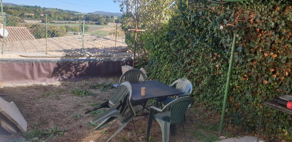 une table et des chaises dans une cour avec un mur dans l'établissement Petite maison avec jardinet, à Revest-du-Bion