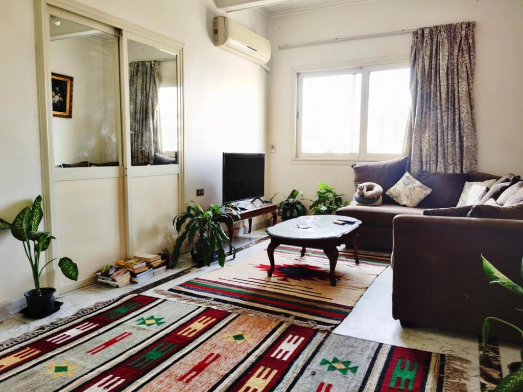 una sala de estar con un sofá y una mesa en Layla Mourad's Stay, en El Cairo