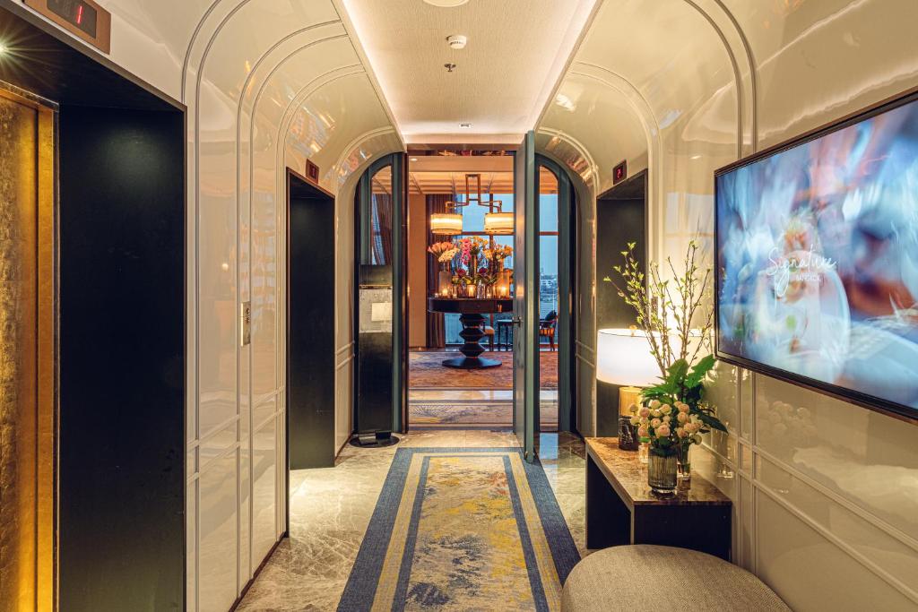 A decorative elevator corridor with a large wall-mounted television.