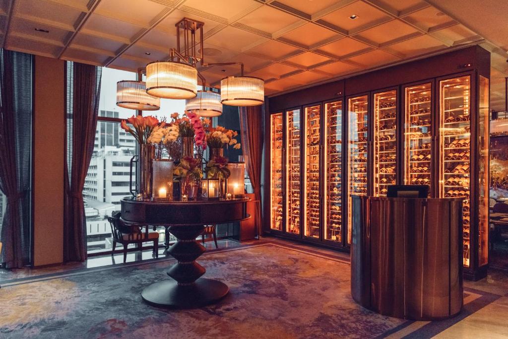 A richly decorated lobby corner with a floral table arrangement beside illuminated display cabinets.