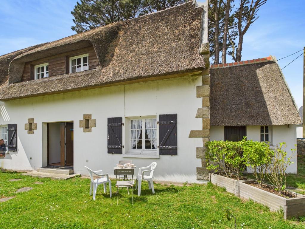 une maison avec une table et des chaises devant dans l'établissement Le Vaisseau - Pour 4 avec jardin dans une chaumière, au Guilvinec