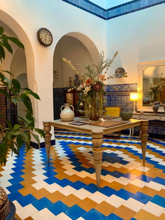 a room with a table with a vase on it at Hostal Casa Alborada in Conil de la Frontera