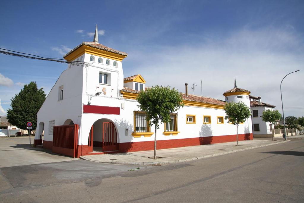 un edificio blanco y rojo al lado de una calle en El Albergue de Herrera en Herrera de Pisuerga