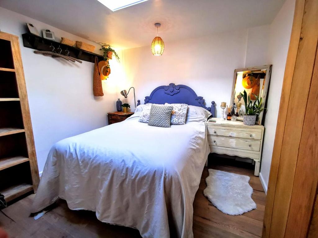 a bedroom with a blue bed and a dresser at Gorgeous Apartment near Bournemouth Beach in Bournemouth