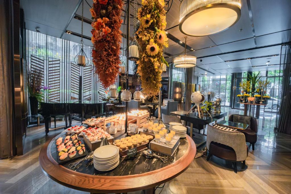 A breakfast buffet with sushi, pastries, fruit, and hanging floral displays.