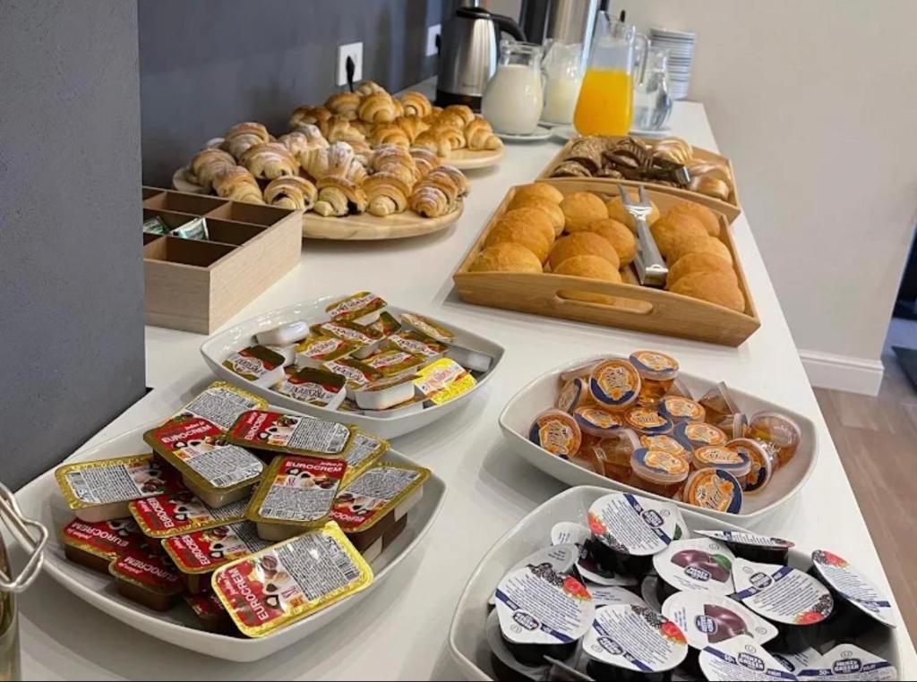a table filled with different types of pastries and donuts at Lux Apartment 14 in Kravlja