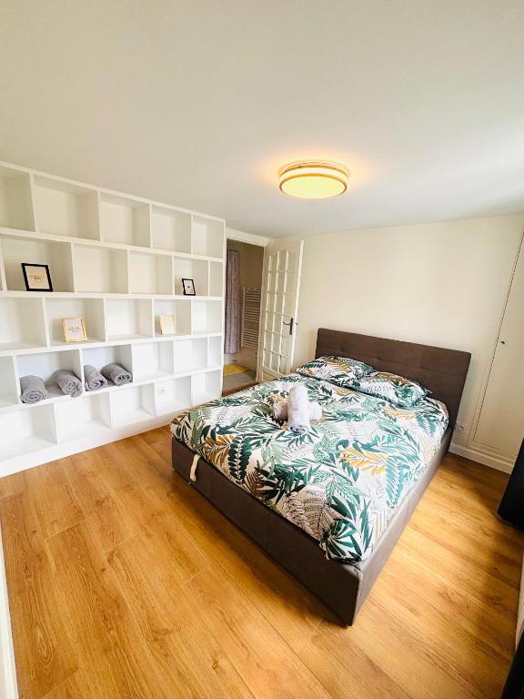 - une chambre avec un grand lit et des étagères blanches dans l'établissement Sentier Marais Bonne Nouvelle, à Paris