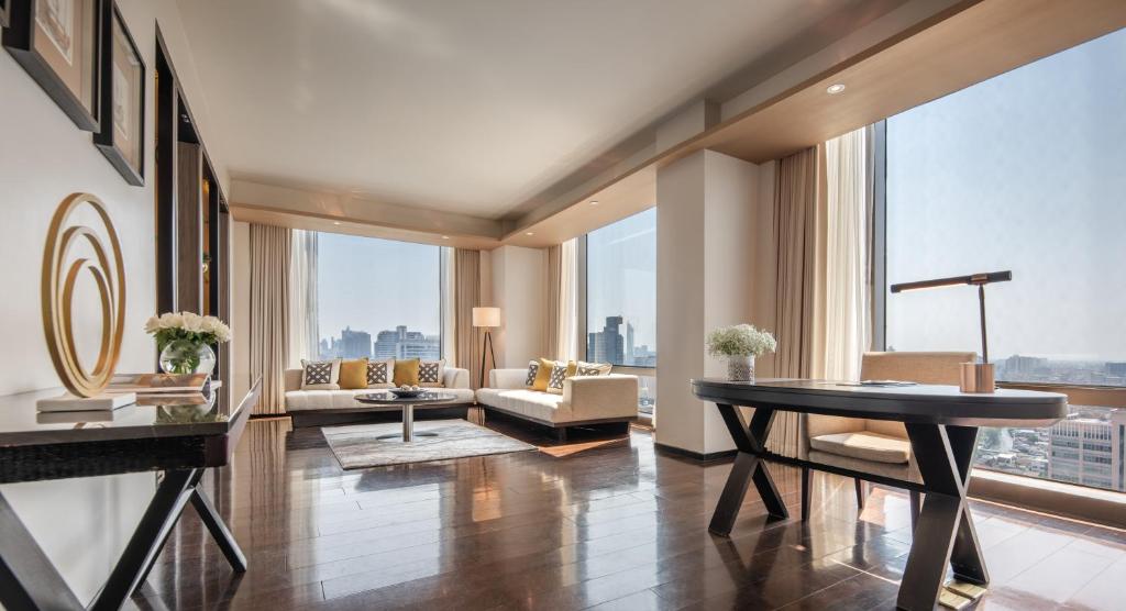A long console desk and lounge occupy a bright corner of the suite.