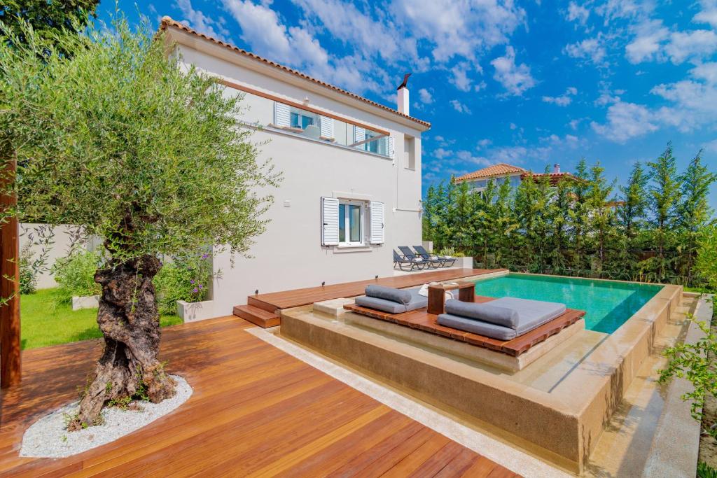 a villa with a swimming pool and a house at Oresteia Executive Villa, a Flamboyant Retreat, By ThinkVilla in Tragaki