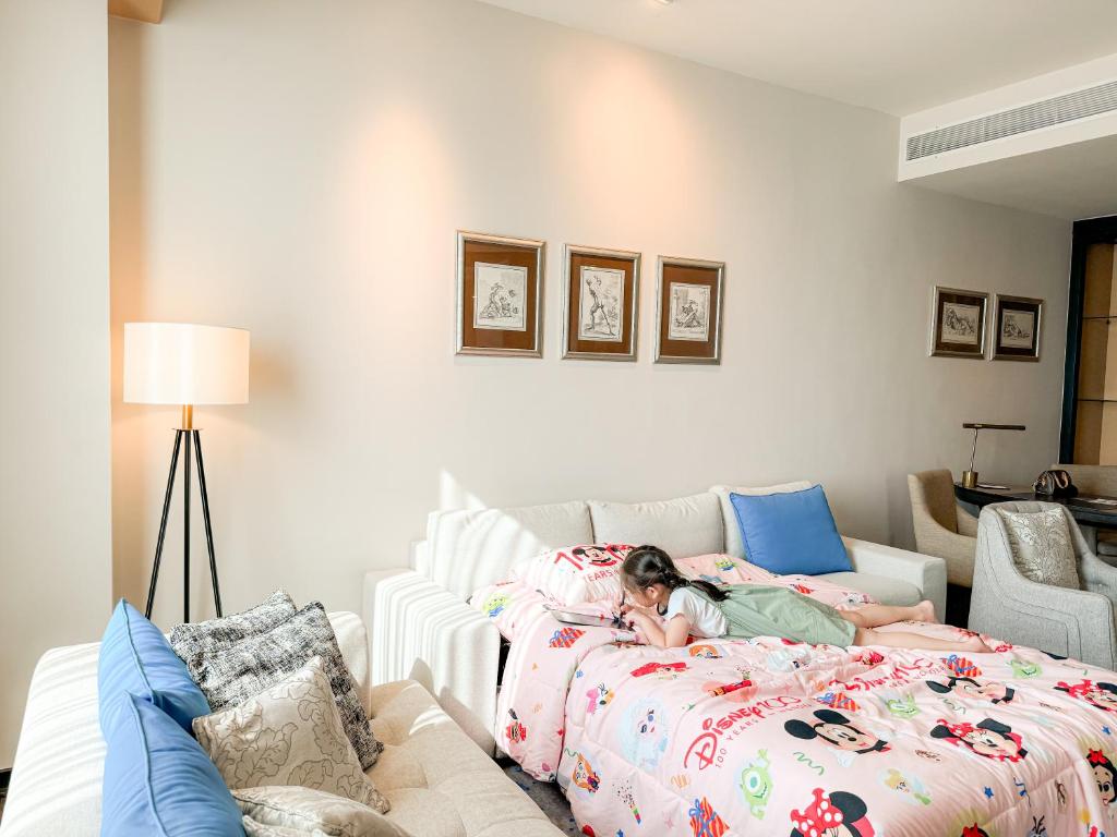 A family sleeping setup with two character-themed beds, a sofa, and a compact desk area.