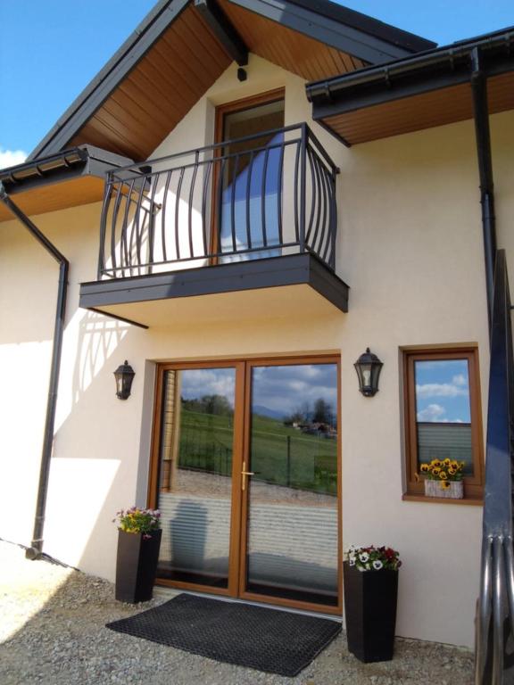 a house with a balcony and a glass door at Apartamenty QUER SPA Jacuzzi i Sauna in Bańska Niżna