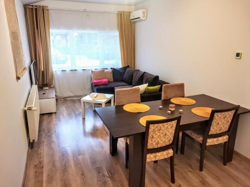 ein Wohnzimmer mit Tisch und Stühlen und einer Couch in der Unterkunft House with a garden in Pipera in Bukarest