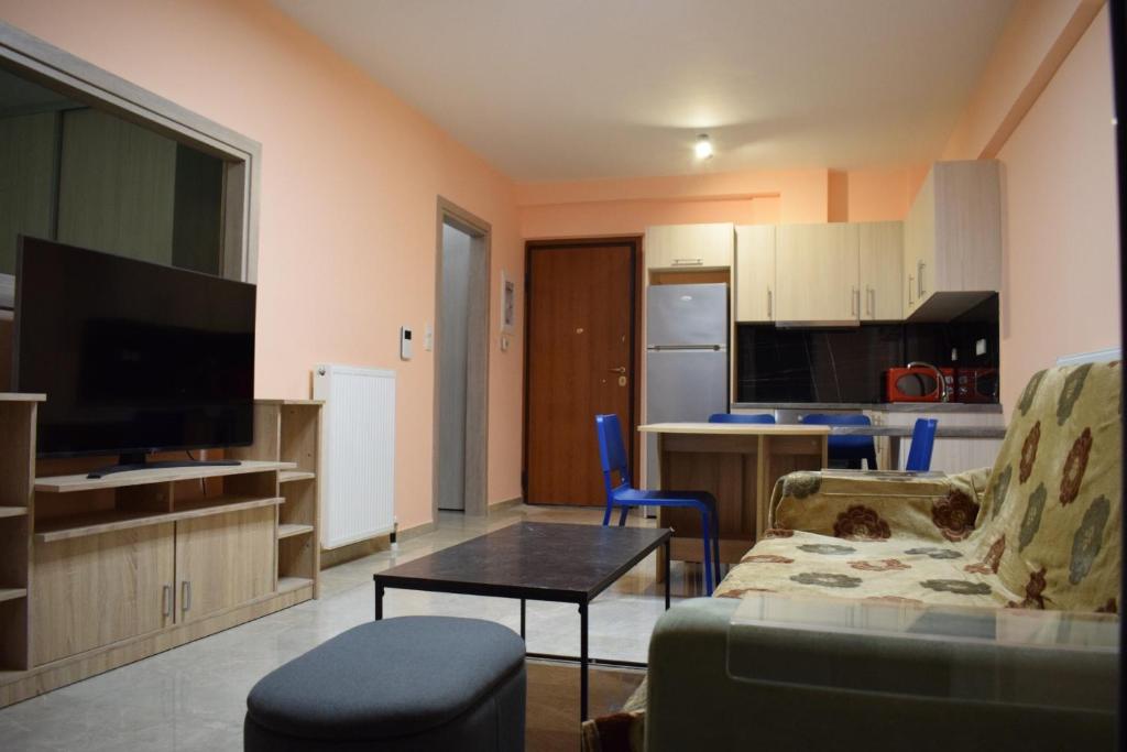 a living room with a couch and a table and a kitchen at SOTOS Loutraki Korinthia Apartments in Loutraki