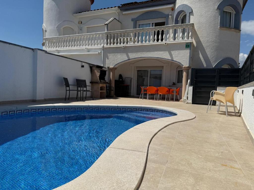 a house with a swimming pool in front of a house at Raquel Koky in Empuriabrava