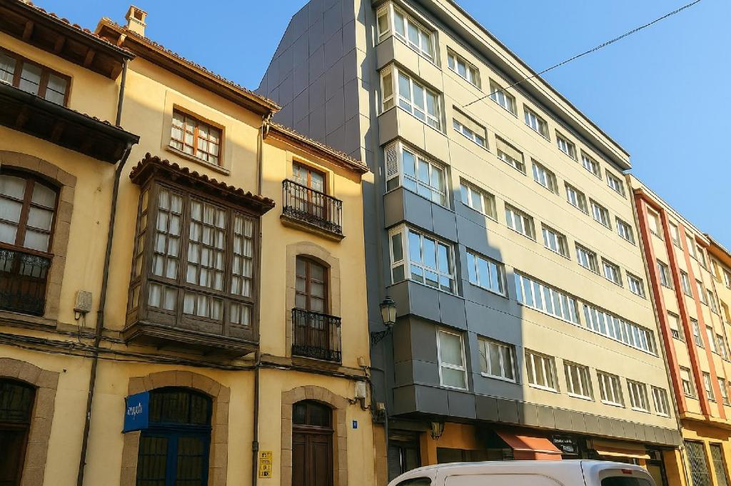a tall building in a city with a van parked in front at Apartamento Casa Pilar in Ribadesella