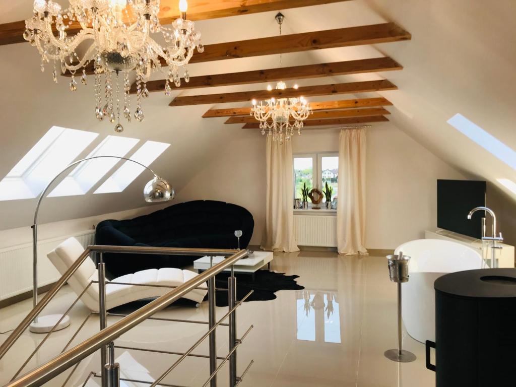 un salon avec un lustre et une table dans l'établissement VILLA SUNSHINE "SUNSHINE SUITE" NAD JEZIOREM KOMINEK i WANNA w SALONIE OGRóD BALKON, à Lipnica