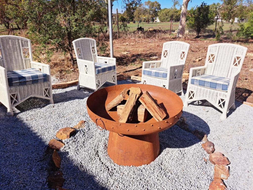 eine Gruppe Stühle und einen Tisch mit einer Feuerstelle in der Unterkunft Bettys Mountain Cottage in York