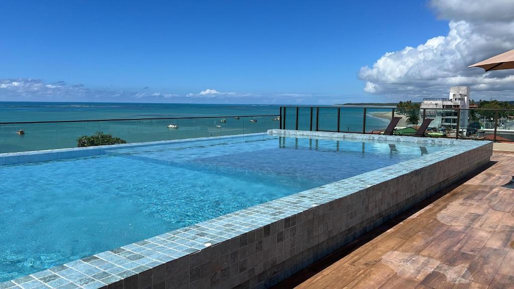 a swimming pool with a view of the ocean at Tamandaré Refúgio Luxuoso com Piscina Infinita e Mar Azul in Tamandaré