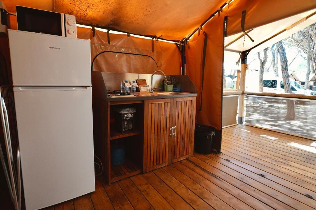 a kitchen with a refrigerator and a wooden floor at Camping 3 Estrellas in Gavà