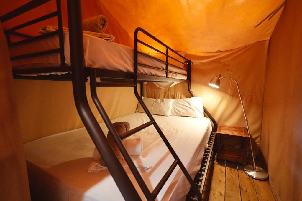 a bedroom with two bunk beds and a lamp at Camping 3 Estrellas in Gavà