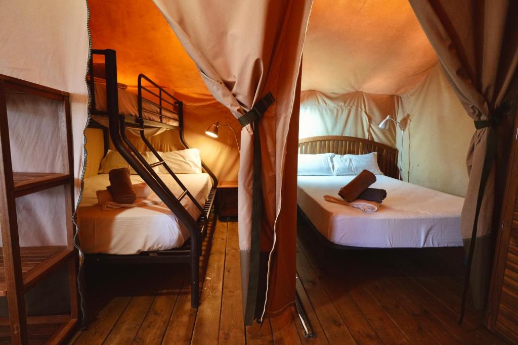 a bedroom with two bunk beds in a tent at Camping 3 Estrellas in Gavà