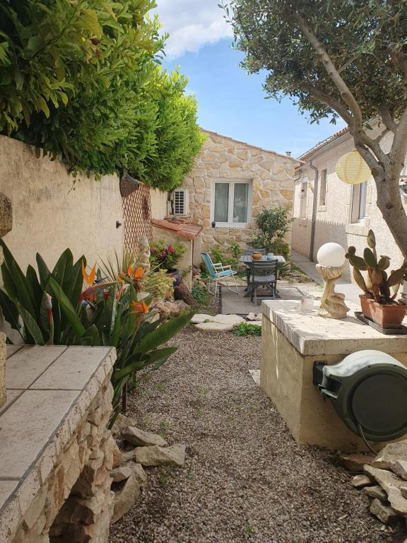 d'un jardin avec un mur en pierre et une terrasse. dans l'établissement Le jardin secret, à Uchaud