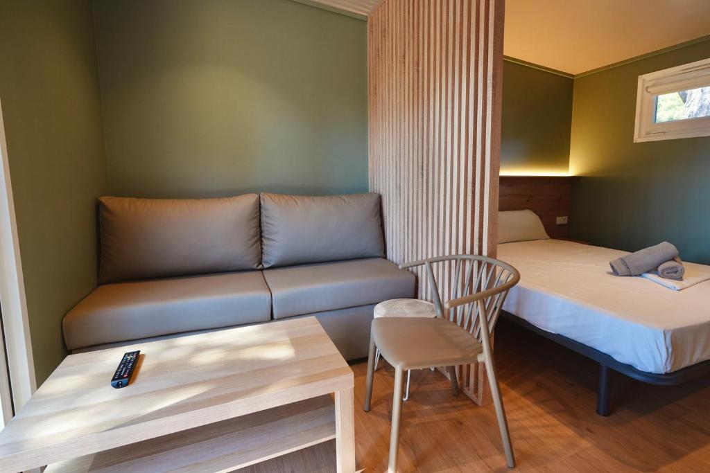a small room with a couch and a bed and a table at Camping 3 Estrellas in Gavà
