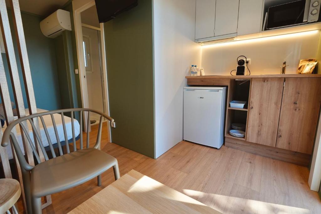 a small kitchen with a chair and a refrigerator at Camping 3 Estrellas in Gavà