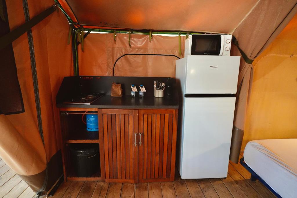 a kitchen with a refrigerator and a stove in a tent at Camping 3 Estrellas in Gavà