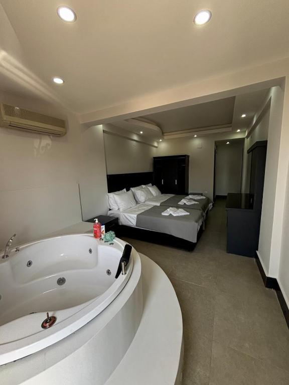 een hotelkamer met een bad en een bed bij Apartment wıth jacuzzı and pool 10 mınutes from the DeadSea in Fethiye
