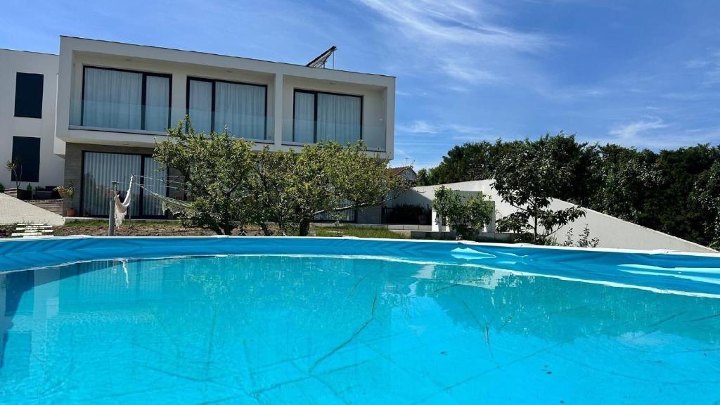 une grande piscine bleue devant un immeuble dans l'établissement Magnolienhaus, à Capelas