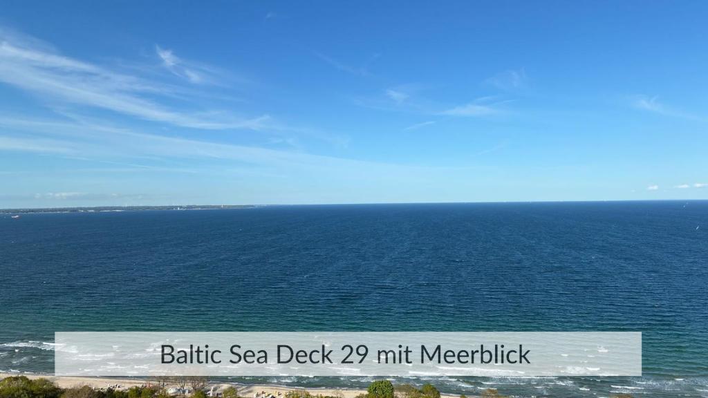 a large body of water with a sign in front of it at Baltic Sea Deck 29 mit Meerblick in Timmendorfer Strand