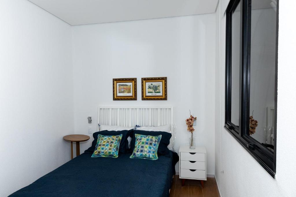 a bedroom with a blue bed with two pillows at Guaja 745 - Apartamento Luna in Belo Horizonte