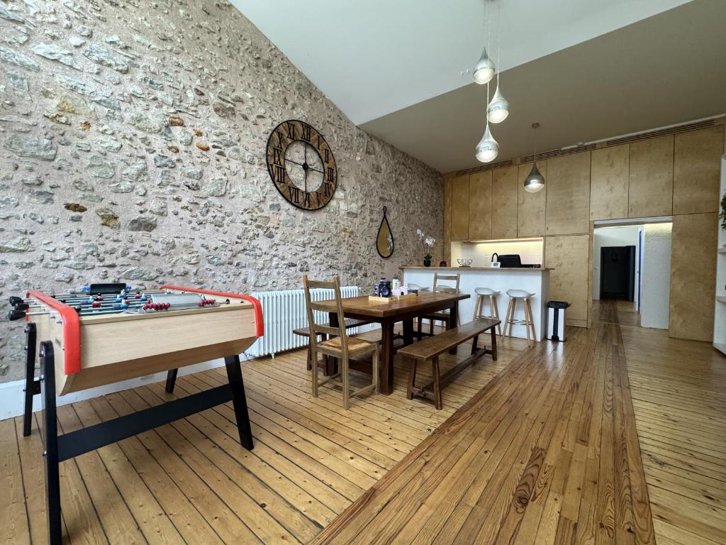 a room with a ping pong table and a stone wall at Le Saint Victeur - 8pers - Babyfoot - Rêve au Mans in Le Mans