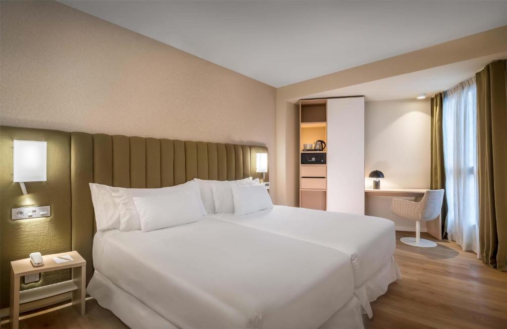 un grande letto bianco in una stanza d'albergo di Barceló Bilbao Nervión a Bilbao