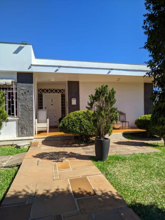a house with a patio and a tree in the yard at Pousada Cyprianos in Júlio de Castilhos