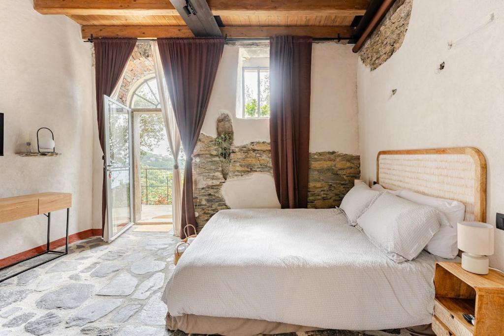a bedroom with a bed and a large window at Casa Sarvaega in Cogorno