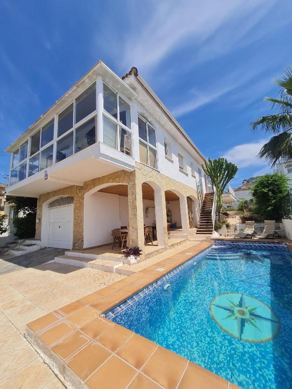 a house with a swimming pool in front of it at Charming Catalan Villa with Pool & Views in Cunit