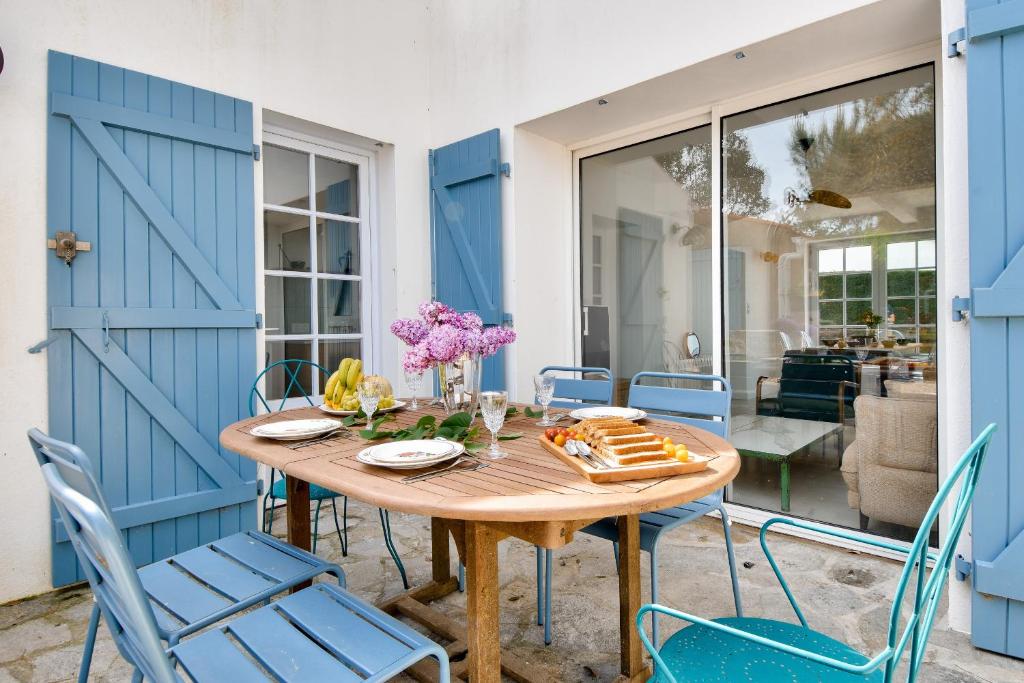 a dining room with blue doors and a table and chairs at À 220m de la plage, maison avec jardin pour 4 in Le Grand Vieil