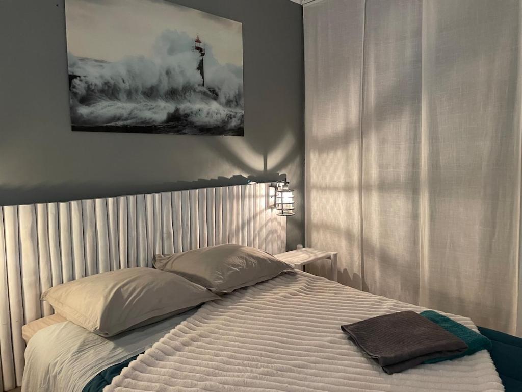 une chambre avec un lit avec un tableau sur le mur dans l'établissement 60 m2 - 6 people, 3-min walk to Azur beach, à La Grande Motte