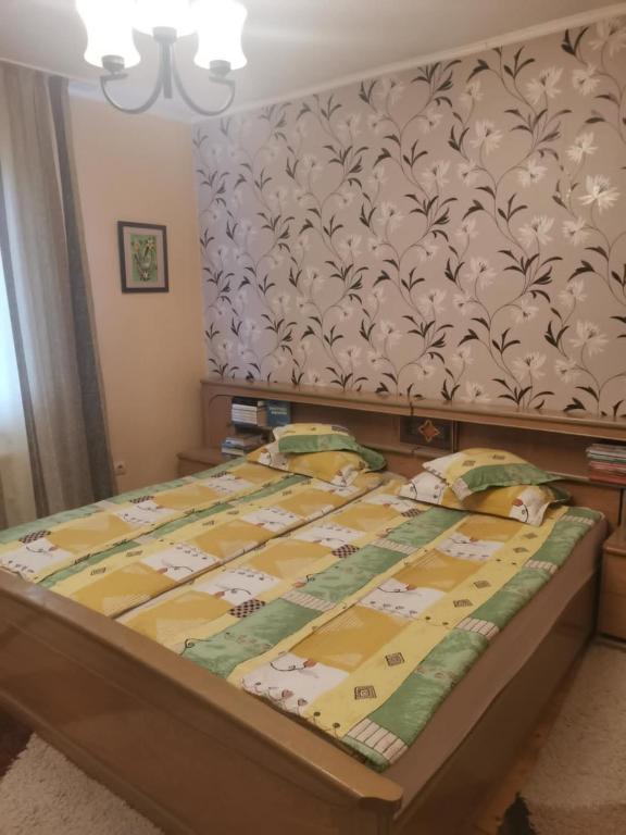a bedroom with a bed with a yellow comforter at Sólyom Katalin vendégház in Văleni