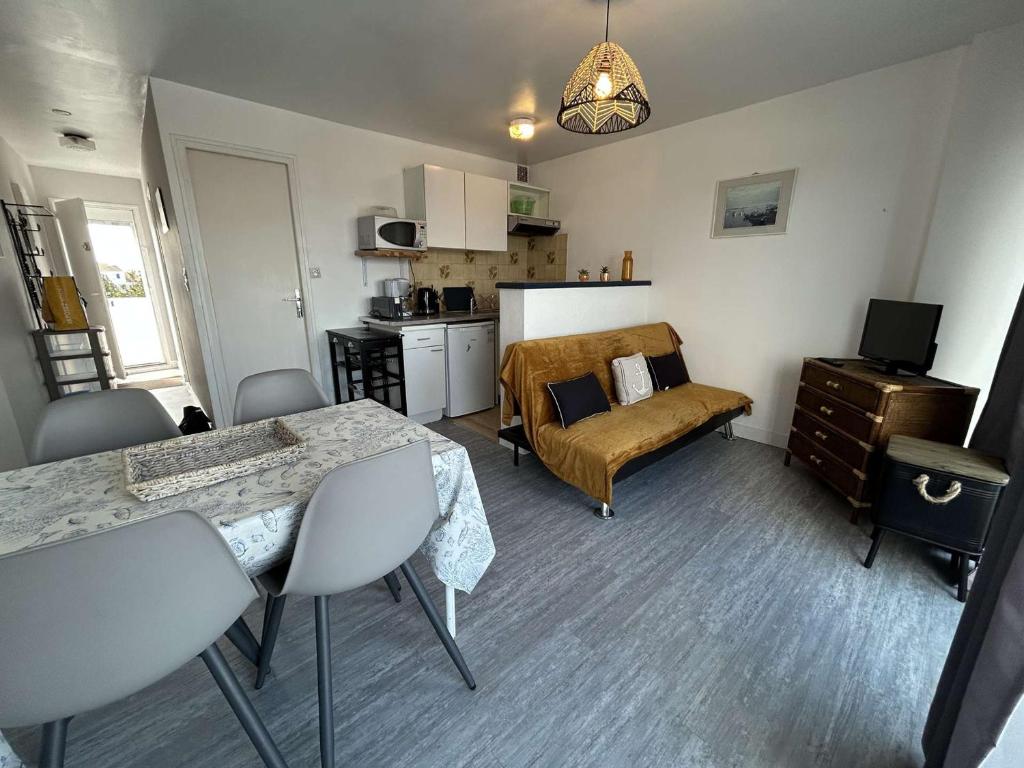 un salon avec un canapé et une table dans l'établissement Appartement 2 pièces avec balcon, proche plage - FR-1-224B-563, à LʼHerbaudière