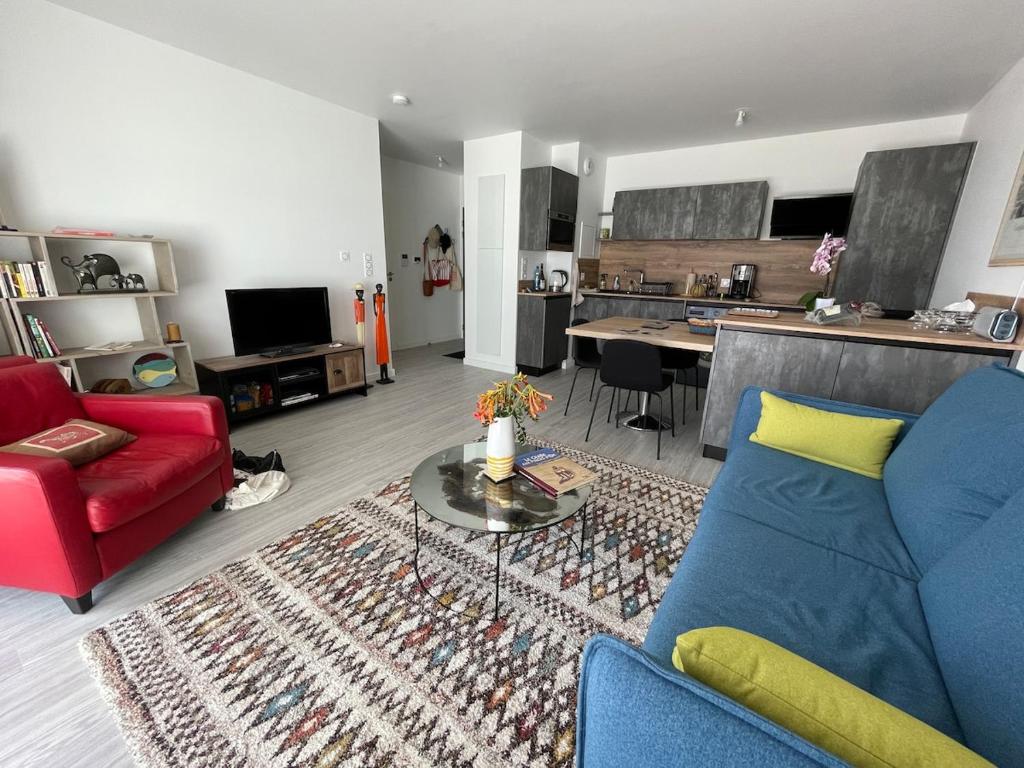 un salon avec un canapé et une table dans l'établissement T2 - terrasse - parking - linge inclu, à Vannes