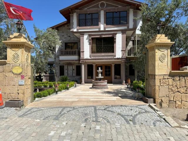a large house with a flag in front of it at Asgard Deluxe Otel in Burhaniye