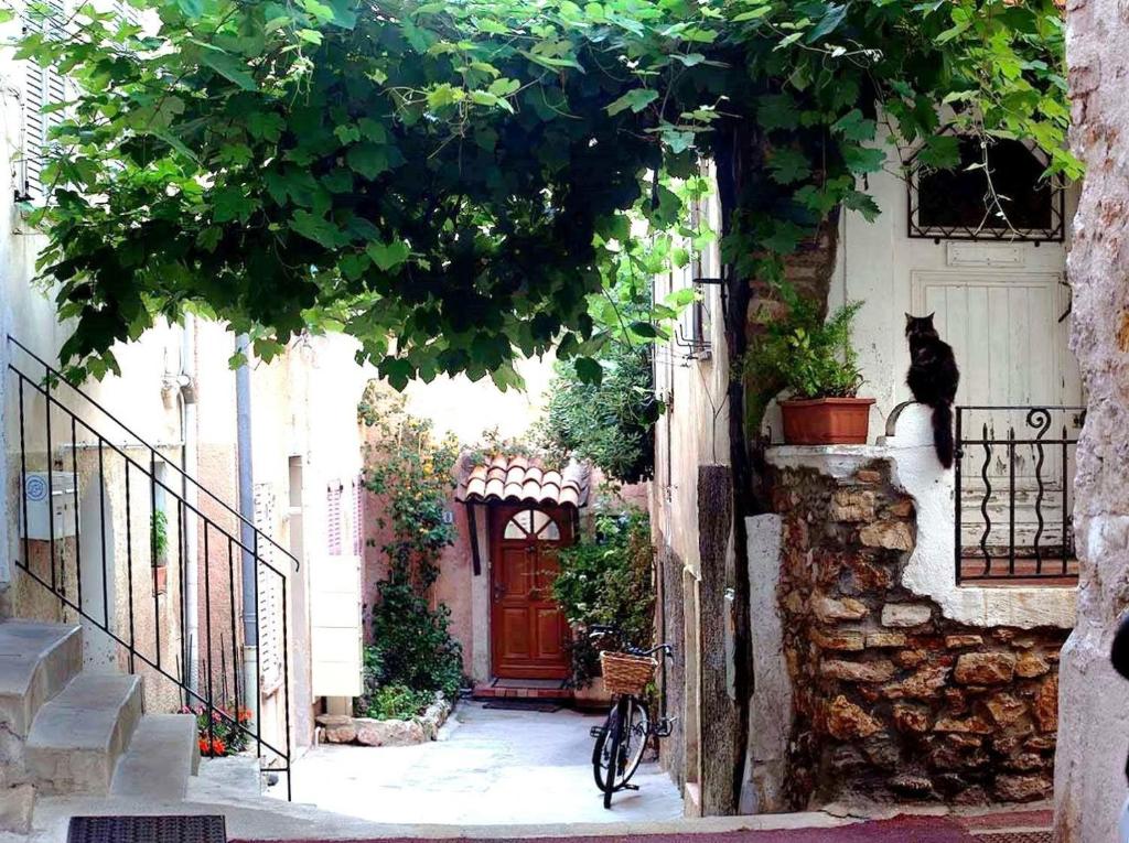 un chat noir assis sur un rebord à côté d'une porte dans l'établissement Koselig leilighet i Antibes, à Antibes