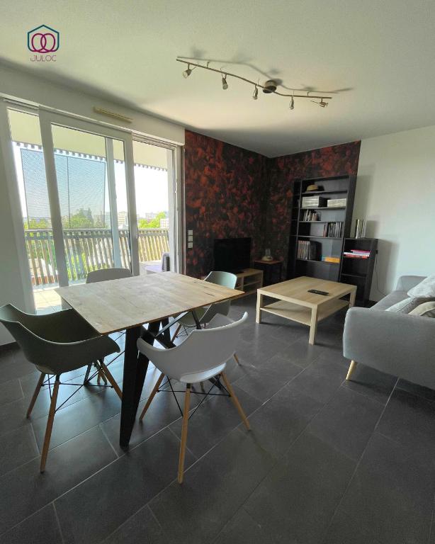 a living room with a wooden table and chairs at Sérénité - Logement calme au coeur de Strasbourg in Strasbourg
